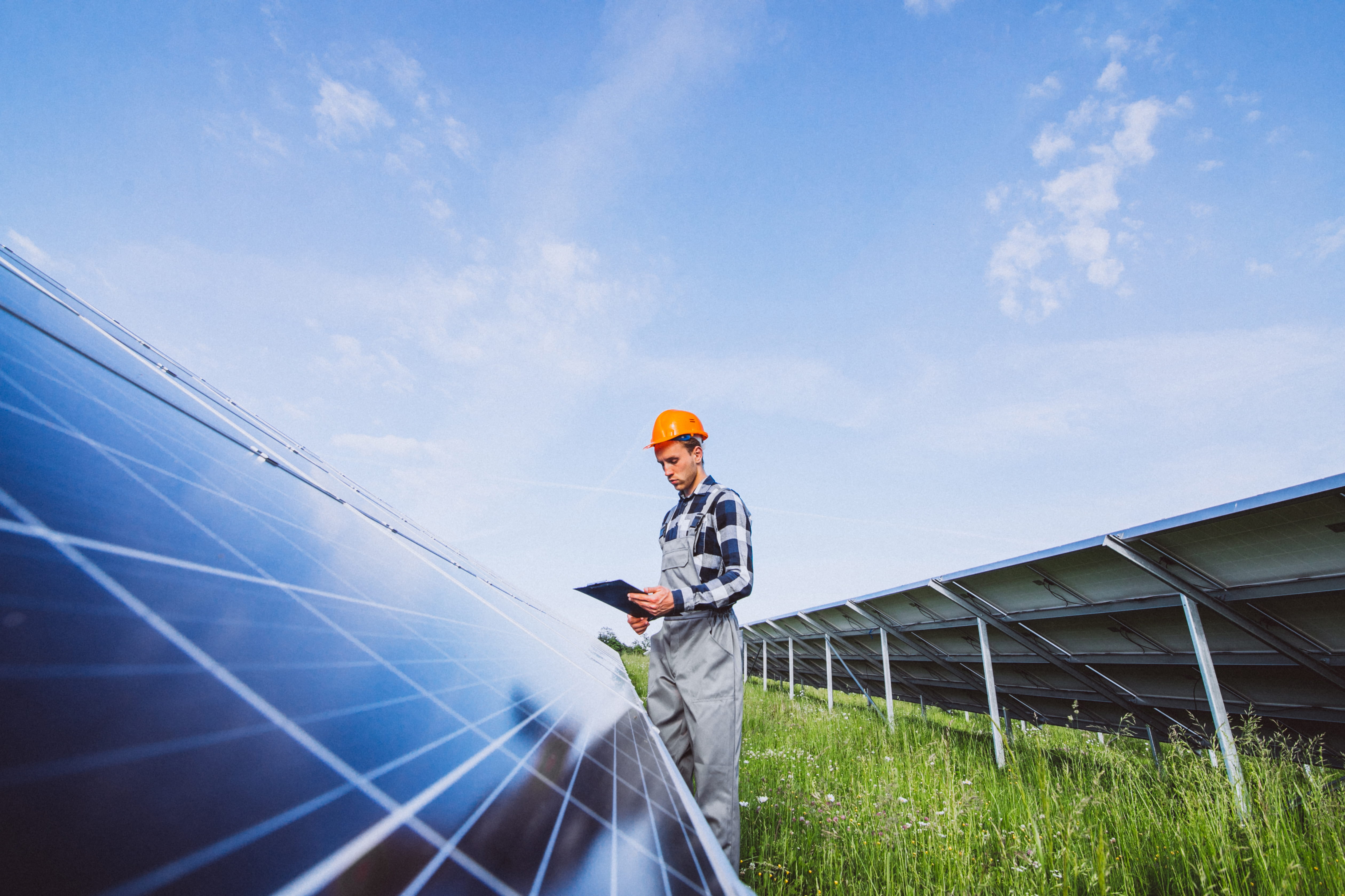 Sur le chantier, une ingénieure vérifie les normes techniques d’éoliennes; elle porte le voile et de l’équipement de protection individuelle.